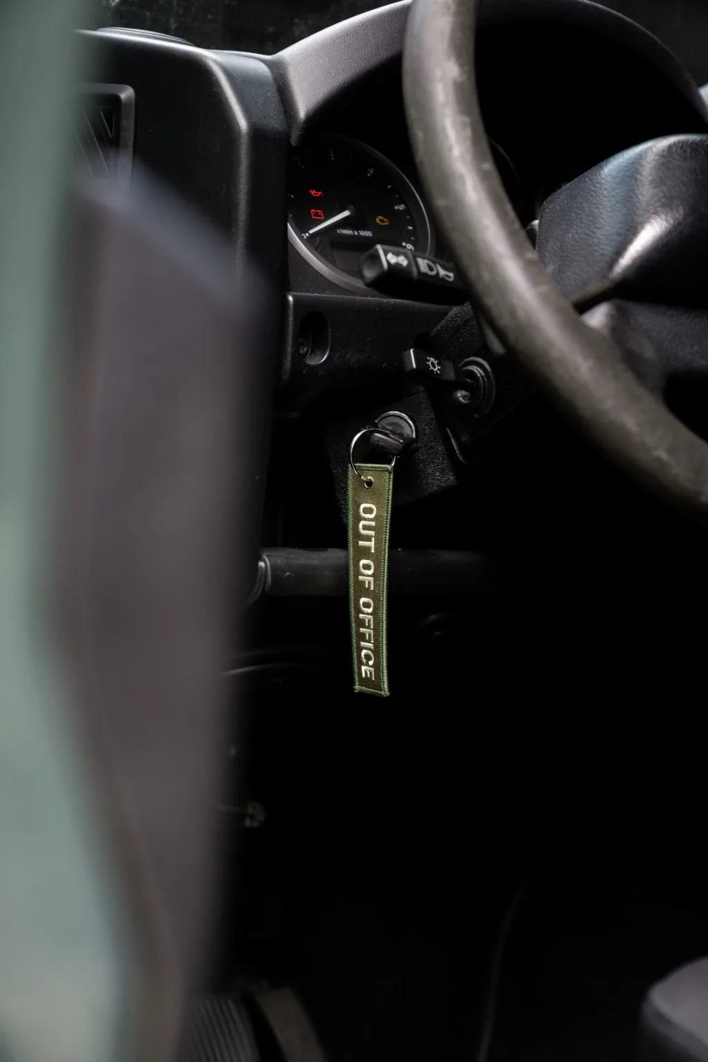 Rottweiler Motors Out of Office woven keychain in Land Rover ignition close-up