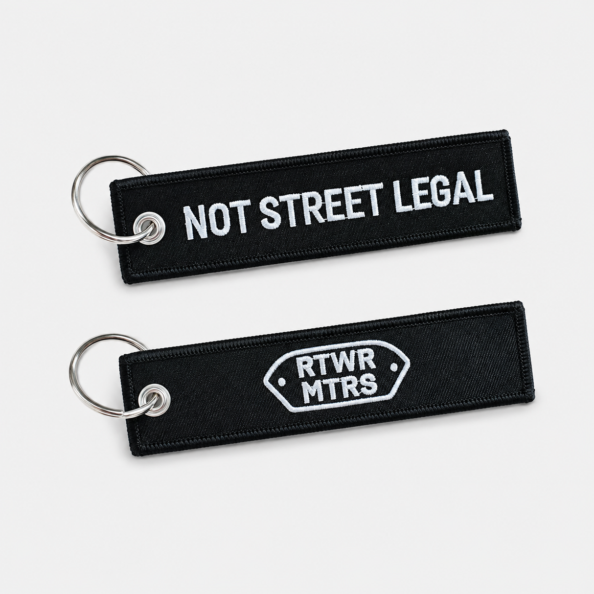 RTWR MTRS Not Street Legal woven keychain on neutral background, front and logo side