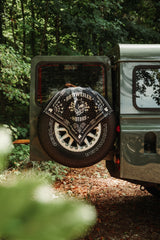 Black Rottweiler Motors bandana draped over the rear spare wheel of a green Land Rover Defender.