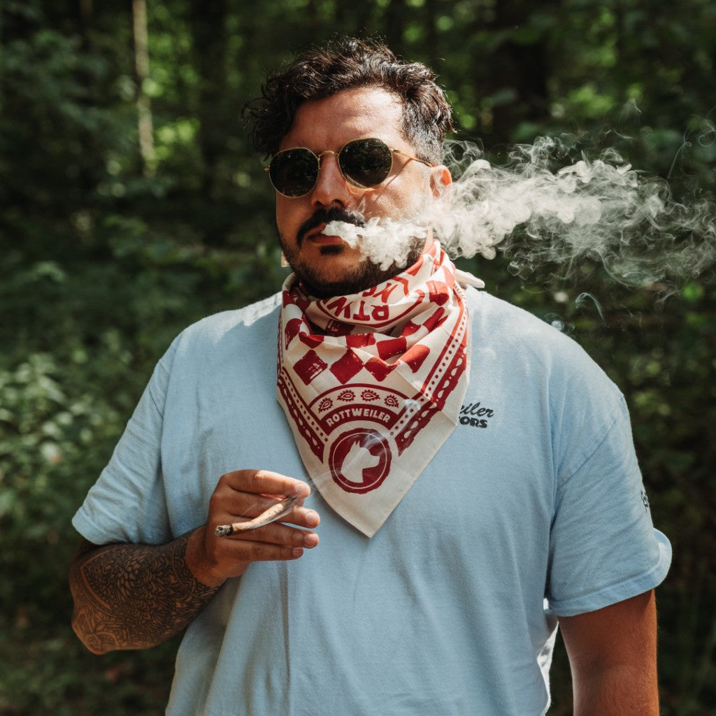 Rider wearing the red and white Rottweiler Motors bandana in a forest setting.