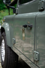 Rottweiler Motors Out of Office woven keychain on Land Rover, logo side