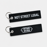 RTWR MTRS Not Street Legal woven keychain on neutral background, front and logo side