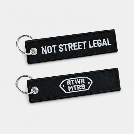 RTWR MTRS Not Street Legal woven keychain on neutral background, front and logo side