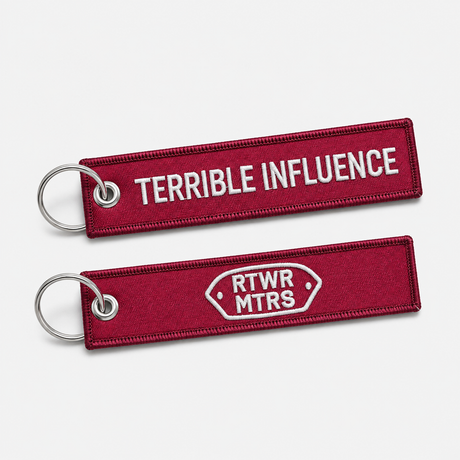 RTWR MTRS Terrible Influence woven keychain on neutral background, front and logo side